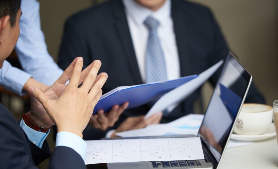 Financial reports on opened laptop of businessman